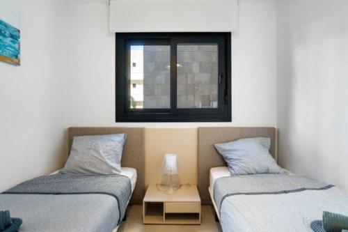 two twin beds in a room with a window at Flamenca Village Resort apt 83 in Orihuela