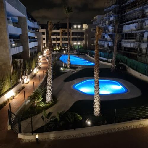 an overhead view of a pool at night with palm trees at Flamenca Village Resort apt 83 in Orihuela