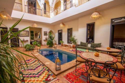 a living room with a pool and a table and chairs at Riad en Exlusivité à 5min de la place jamaa el fna in Marrakesh