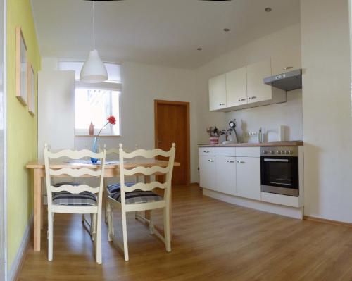 a kitchen and dining room with a table and chairs at Ferienwohnung Erz in Kinheim