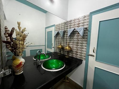 ein Badezimmer mit einem grünen Waschbecken und einem Spiegel in der Unterkunft *URBAN HOME*-A Luxe Contemporary 1BHK Apartment in Guwahati