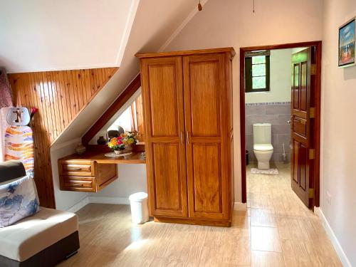 a bathroom with a staircase with a toilet and a wooden cabinet at Belle Montagne Holiday Apartments in Grand'Anse