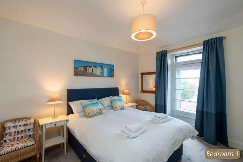 1 dormitorio con 1 cama grande y ventana en TenSea en North Berwick