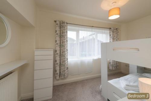 1 dormitorio con cama y ventana en TenSea en North Berwick