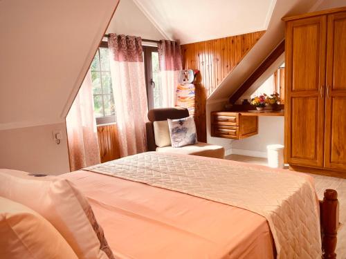 a bedroom with a bed and a chair and a window at Belle Montagne Holiday Apartments in Grand'Anse