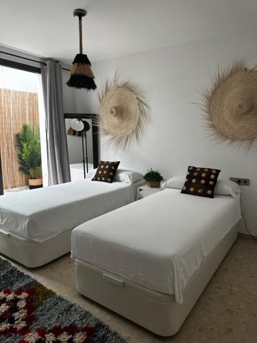 1 Schlafzimmer mit 2 Betten und einem Fenster in der Unterkunft LUXURY House with Stunning Sea Views - Ses Salines in La Savina