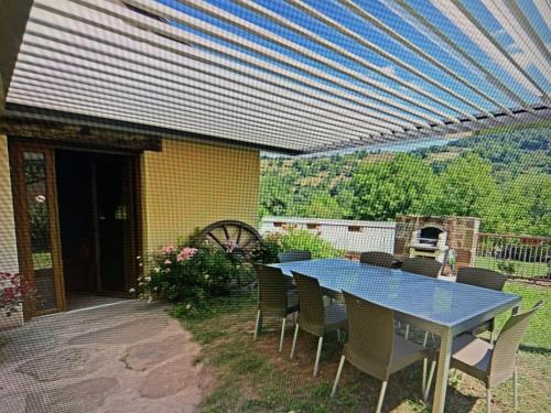 a blue table and chairs on a patio at Domaine de Jouani - Pergola in Villecomtal