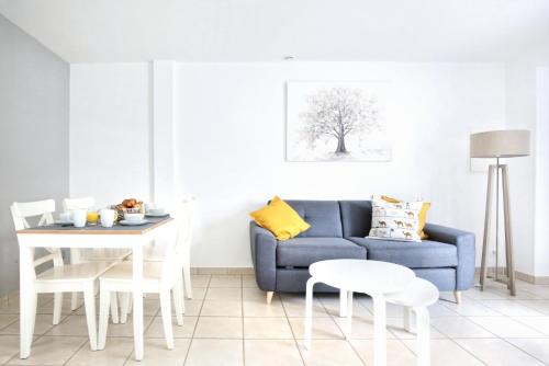 salon z niebieską kanapą i stołem w obiekcie La Saline - Second Souffle - Cherbourg w mieście Cherbourg en Cotentin