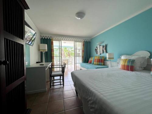 ein Hotelzimmer mit einem Bett, einem Schreibtisch und einem Schlafzimmer in der Unterkunft Passion Caraïbe in Sainte-Luce