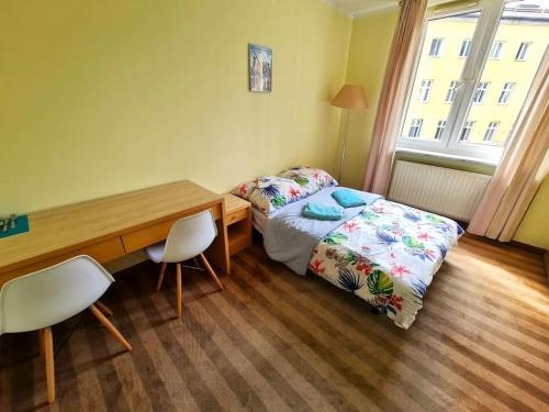 um pequeno quarto com uma cama, uma secretária, uma mesa e cadeiras em Fantastic - Z6 Room - 303B em Varsóvia