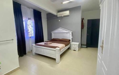 een slaapkamer met een bed en een raam bij Haris Homestay 3 Bedroom and 2 Bathroom in Kota Bharu
