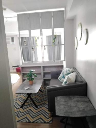 a living room with a couch and a table at Abreeza place T1-1702 in Davao City