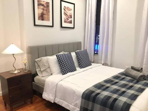 ein Schlafzimmer mit einem Bett und einem Tisch mit einer Lampe in der Unterkunft Cozy Studio Chinatown! Location! in New York