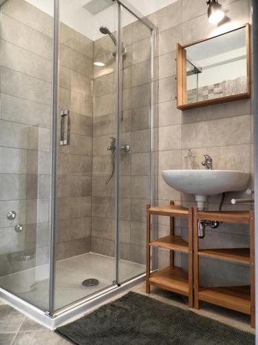 a bathroom with a shower with a sink and a mirror at Apartment Kiki Candy in Malinska