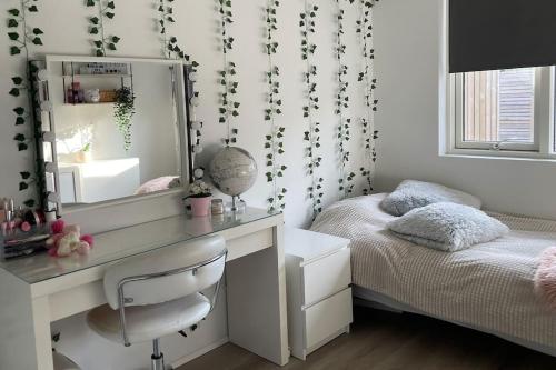 a bedroom with a desk and a bed with a mirror at A cozy home away from home in Hveragerði