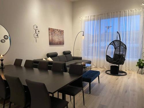 een woonkamer met een tafel en stoelen en een bank bij A cozy home away from home in Hveragerði