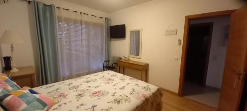 a bedroom with a bed and a window and a television at Apartment in the center of Tavira with swimming pool and garage in Tavira