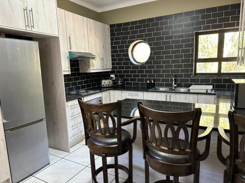 a kitchen with two chairs and a counter with a sink at Beautiful Home in Houghton in Johannesburg