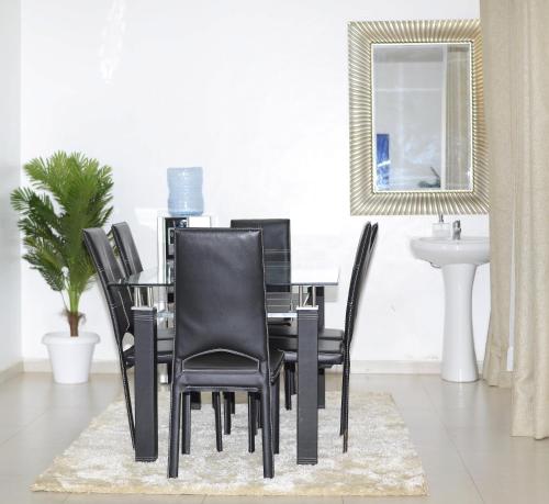 uma mesa de jantar com cadeiras pretas e um lavatório em Sofitel Executive 3 bedrooms milimani em Kisumu