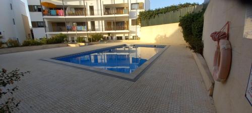a swimming pool in front of a building at Apartment in the center of Tavira with swimming pool and garage in Tavira
