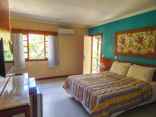 a bedroom with a bed and two windows in it at Hotel Mar de Cabo Frio in Cabo Frio