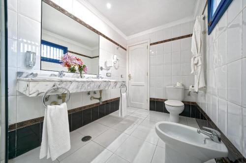 ein weißes Bad mit einem Waschbecken und einem WC in der Unterkunft One bedroom with pool at 500m from Playa Chica, Puerto del Carmen in Puerto del Carmen