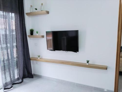 ein Wohnzimmer mit einem TV an der Wand in der Unterkunft Apartamento Ico en El Médano in El Médano
