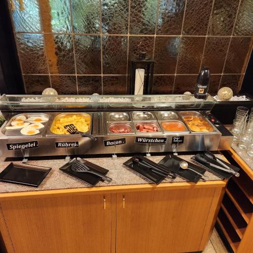 een buffet met veel verschillende soorten eten op een aanrecht bij Siegerland-Hotel in Freudenberg
