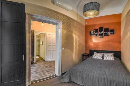 sypialnia z łóżkiem i pomarańczową ścianą w obiekcie Your Worry Free Apartment Close To Parliament w Budapeszcie