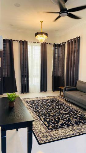- un salon avec un canapé et un ventilateur de plafond dans l'établissement Kaklah Cherang Homestay, à Kota Bharu