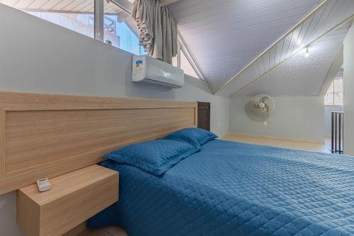a bedroom with a bed with a blue comforter at Excelente Apartamento 190m da Praia de bombinhas - 3 dorms 6 pessoas in Bombinhas