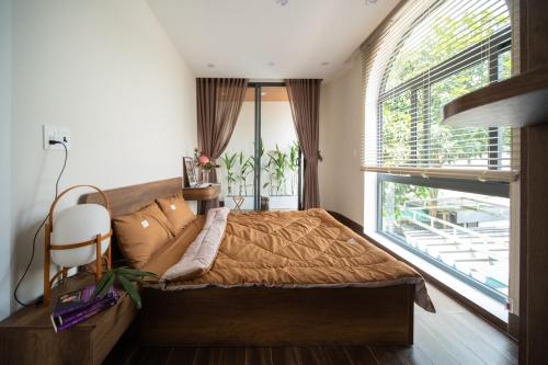 - une chambre avec un lit et une grande fenêtre dans l'établissement Dk House Hue, à Hue