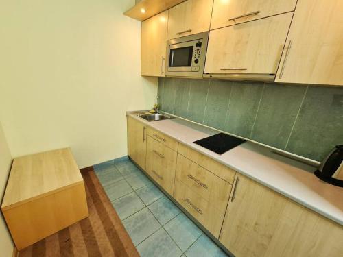 uma cozinha com armários de madeira e um micro-ondas em Fantastic - Z6 Room - 304B em Varsóvia