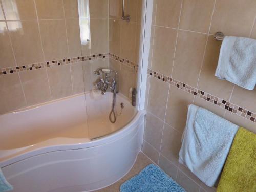a bathroom with a bath tub and a sink at Pump Lodge in Weymouth