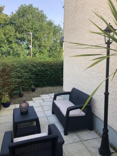 a patio with a couch and chairs and a lamp at Mill Park Stay Room ONLY with use of kitchen & bathroom in Derry Londonderry