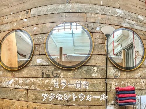 zwei Spiegel an einer Holzwand mit Schreiben in der Unterkunft Fukuoka - House / Vacation STAY 4898 in Fukuoka