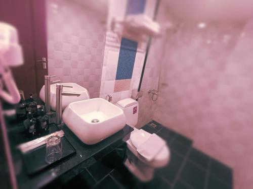 a bathroom with a white toilet and a sink at DE Hotel in Phnom Penh