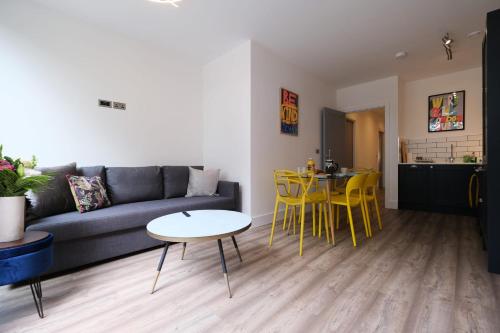 un soggiorno con divano, tavolo e sedie gialle di Brand New Ground Floor Apartment with Balcony a Londra