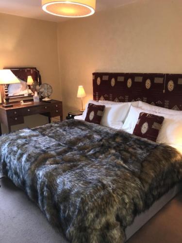 a bedroom with a large bed and a desk at Walter de Cantelupe Inn in Worcester