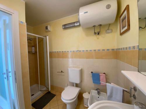 ein Bad mit einem WC, einer Dusche und einem Waschbecken in der Unterkunft Gaia Apartment un gioiello in Grado