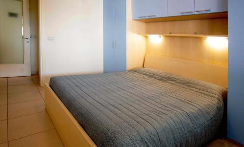 ein kleines Schlafzimmer mit einem Bett in einem Zimmer in der Unterkunft Gaia Apartment un gioiello in Grado