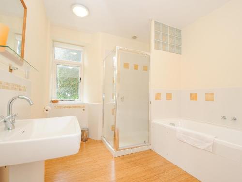 a white bathroom with a sink and a shower at Carneadon Farmhouse in Launceston
