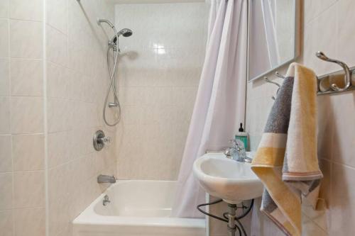 Delightful 2BR Apartment in NYC! في نيويورك: حمام مع حوض ودش ومغسلة