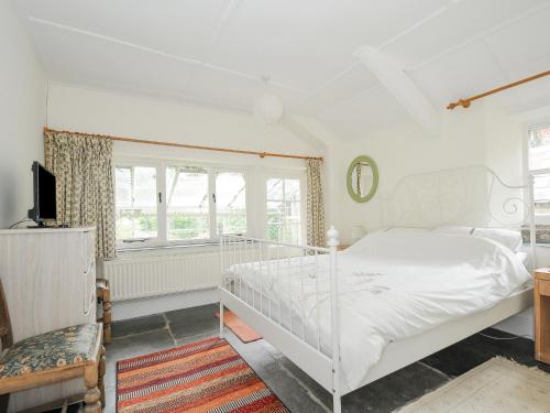 a white bedroom with a bed and a window at Carneadon Farmhouse in Launceston