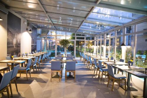 a restaurant with tables and chairs in a building at Avangard Resort in Świnoujście