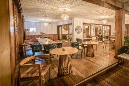 a restaurant with tables and chairs in a room at Carlore Hotel Taíba in Taíba