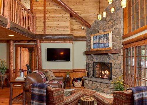 a living room with a stone fireplace and a tv at The Chatwal Lodge (All-Inclusive) - in The Unbound Collection by Hyatt in White Lake