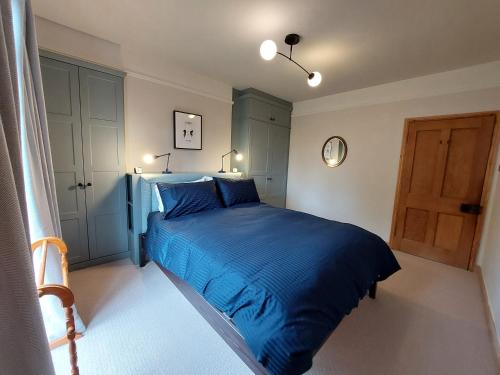 a bedroom with a blue bed and a door at Cosy flat in Innerleithen in Innerleithen
