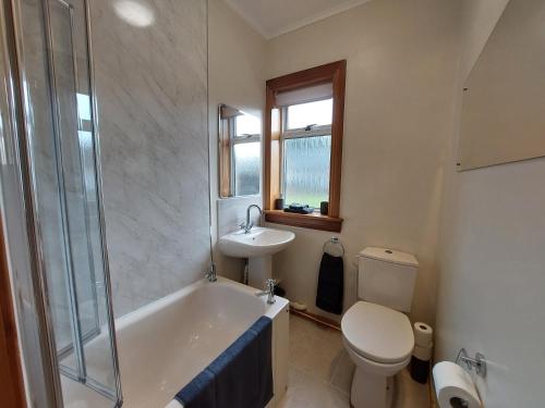a bathroom with a tub and a toilet and a sink at Cosy flat in Innerleithen in Innerleithen