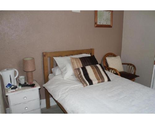 a bedroom with a bed and a table with a lamp at The Little Emily - Room Only in Great Yarmouth
